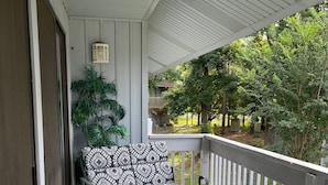 A covered porch with a sofa and chairs, a small table, and a potted plant. - Comfortable Daphne Condo near Bay, Fairhope, and Mobile;  Short Drive to Beaches (Daphne)
