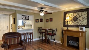 A dining area with a wooden table, chairs, and a fireplace. - Comfortable Daphne Condo near Bay, Fairhope, and Mobile;  Short Drive to Beaches (Daphne)