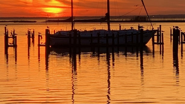 A boat docked at a pier with a sunset in the background. - Comfortable Daphne Condo near Bay, Fairhope, and Mobile;  Short Drive to Beaches (Daphne)