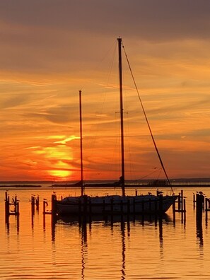 Un bateau était amarré à un quai, avec un coucher de soleil en arrière-plan.