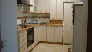 Una cocina con armarios de madera, un lavamanos, una estufa y un refrigerador.