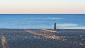 A beach scene with a person fishing. - Lovingly furnished house in a quiet location with heated pool and sea views (Gennadi, Rhodos)