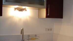 A modern kitchen with a stainless steel sink, a built-in oven, and a microwave above the countertop. - Apt T3 air-conditioned, on the 1st floor of a character residence in CAHORS  (Cahors)