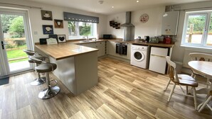 A modern kitchen with a skylight, built-in appliances, and a view of the garden. - Mill Lane Cottage, a pretty cottage in beautiful countryside, 4 miles from Bath. (Bath)
