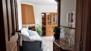 A bedroom with a bed, bedside table, and a wooden wardrobe. - "Beachfront apartment - Praia do Furadouro with Wi-Fi" (Ovar)