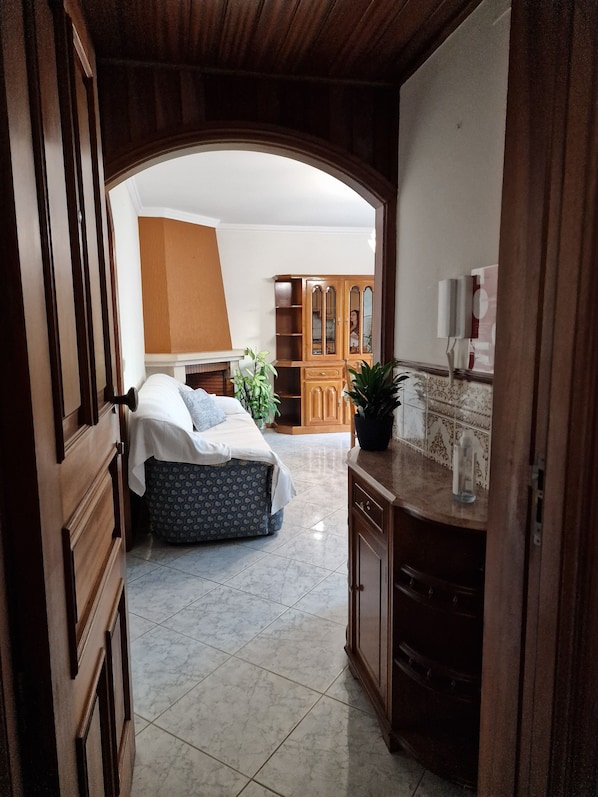 A bedroom with a bed, bedside table, and a wooden wardrobe.