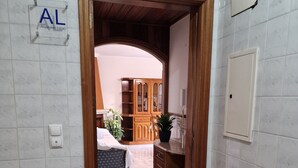 A hallway with a wooden door leading to a room with a bed and a cabinet. - "Beachfront apartment - Praia do Furadouro with Wi-Fi" (Ovar)