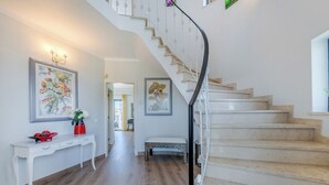 Un escalier avec une rampe blanche menant à un deuxième étage.