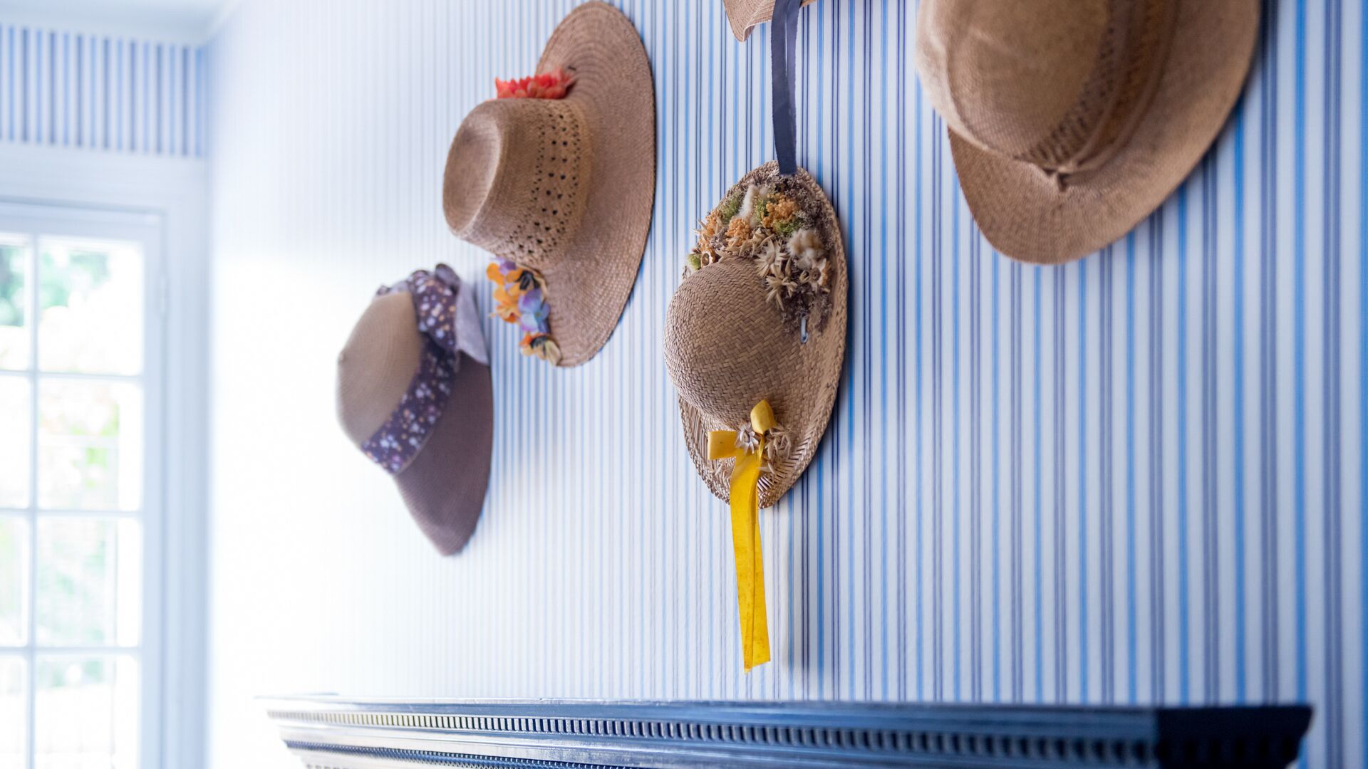 A wall with several hats hanging on it.