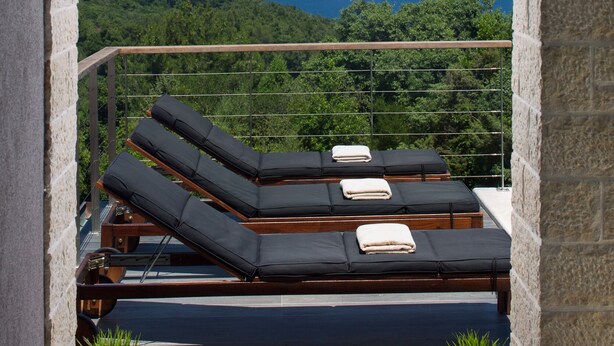 Un balcón con sillones de descanso y vista al mar.