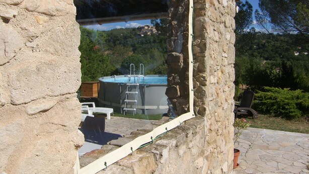Un bâtiment en pierre doté d’une piscine et d’une échelle permettant d’y accéder.