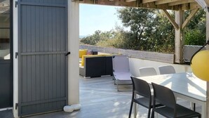An outdoor patio with a table and chairs, a sofa, and a wooden pergola structure. - House sea view in Chaucre beach 80 m panoramic solarium  (Saint-Georges-D'oléron)