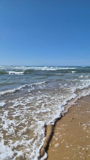 Una playa con olas lamiendo suavemente la orilla.