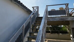 A metal staircase leading to a balcony with a view of the sky and a building in the background. - House sea view in Chaucre beach 80 m panoramic solarium  (Saint-Georges-D'oléron)