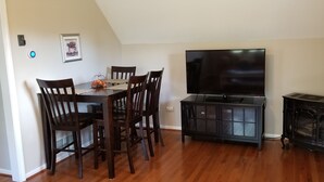 Ein Essbereich mit Holztisch und -stühlen, einem Fernseher und einem Schrank.