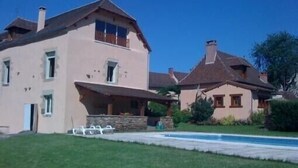 Una casa de dos pisos con piscina en el jardín delantero.