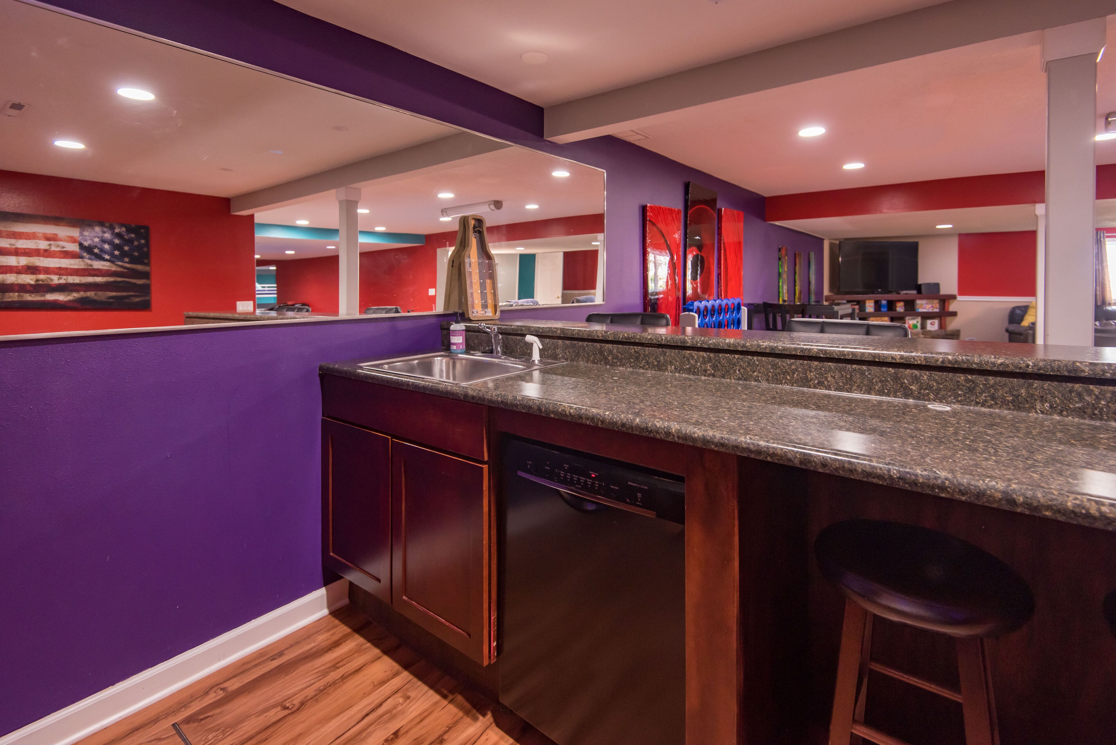A modern kitchen with a granite countertop, stainless steel sink, and a dishwasher.