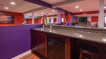 A modern kitchen with a granite countertop, stainless steel sink, and a dishwasher.