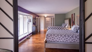 A bedroom with two beds, wooden flooring, and a view of the outside. - LUXURY GETAWAY! ARCADE, POOL TBL, PING PONG, HOT TUB, DECK! ACCESS TO POOLS! (Waukee)