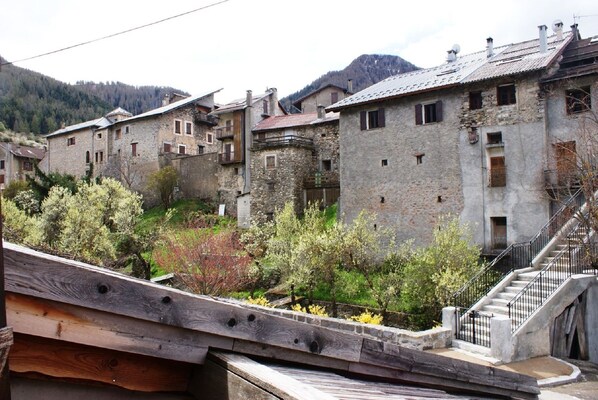 A stone building with a staircase leading up to a balcony.
