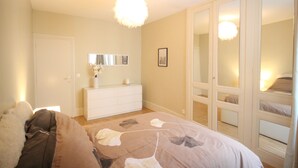 Ein Schlafzimmer mit Bett, Kommode und Kleiderschrank.