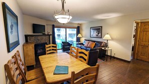 Una sala de estar con chimenea, una mesa de comedor y un sofá.