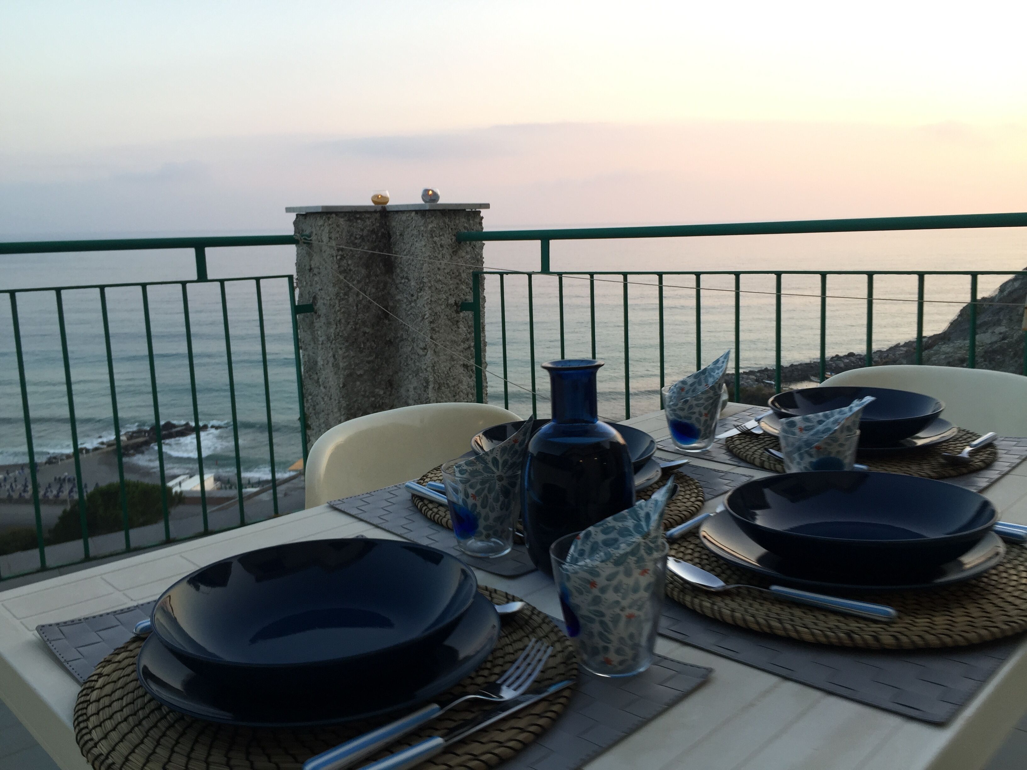 A table set for a meal with a view of the ocean.