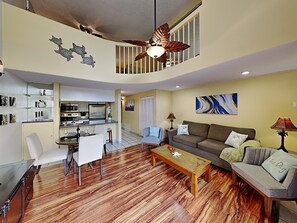A spacious living area with a kitchen, a dining table with chairs, a sofa, and a coffee table.