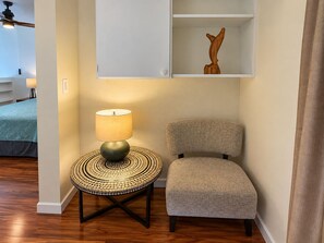 A room with a round table, a lamp, a chair, and a cabinet with a decorative item. - Where Families Gather Kihei 2BR Loft Condo Heated Pool Hot Tub Near Beach (Kihei)