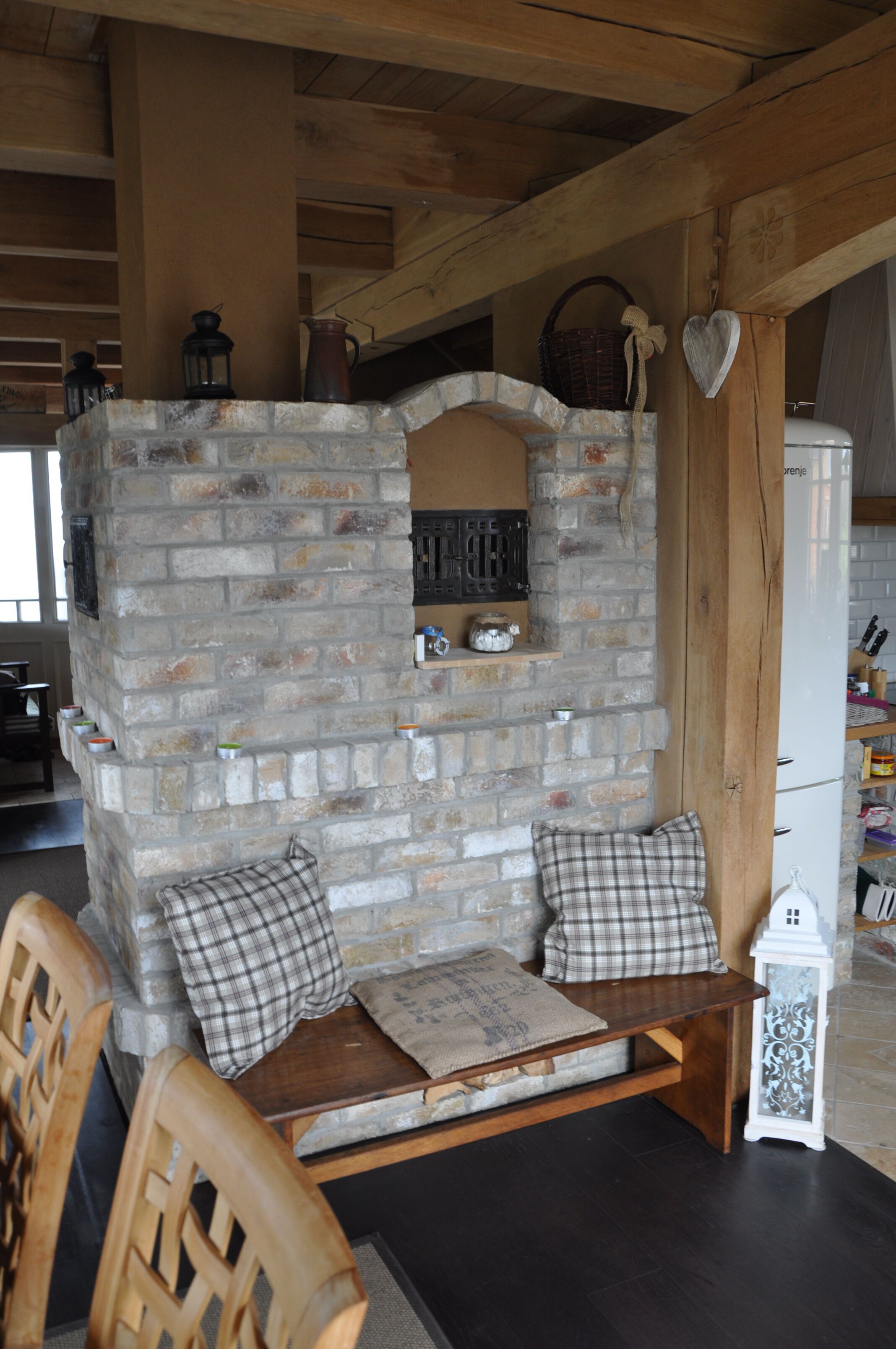 A cozy seating area with a stone wall, wooden bench, and cushions.