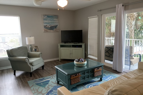 Beachy, inviting living room that includes a queen sleeper sofa