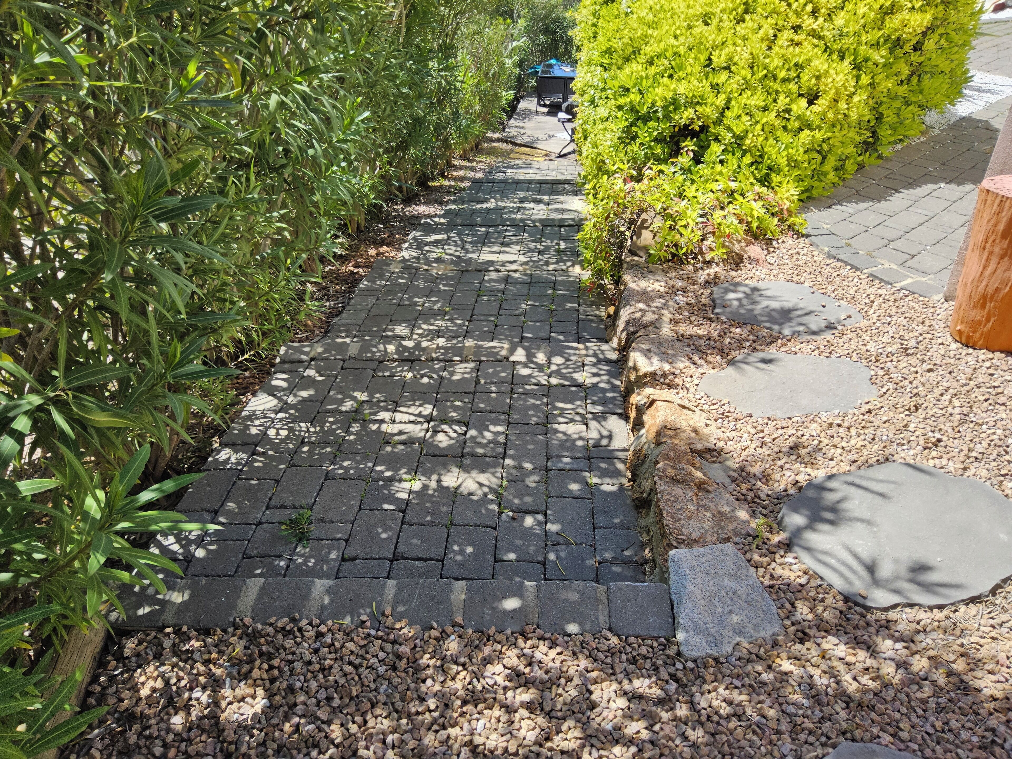 Un camino pavimentado con borde de piedra y grava.