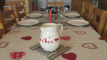 Une table à manger dressée avec des assiettes, un pichet et une bougie.