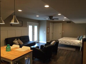 A compact living space with a sofa, a dining table, a bed, and a ceiling fan. - Fresh bed and fresh bread in beautiful studio! (Mesa)