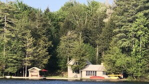 A lakeside cabin with a dock, surrounded by dense forest. - Adirondack Beauty! 110 ft Lake Frontage On Brant. Lake - Beach; Kayaks, Canoes (Greig)