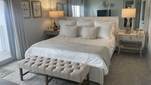 A neatly arranged bedroom with a large bed, a bedside table with lamps, and a bench. - Beachfront cozy 2 bedroom 2 bath (Panama City Beach)
