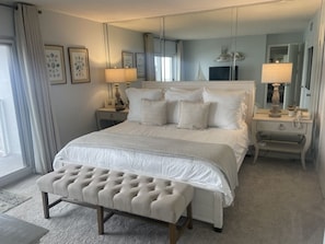 Restful retreat with a large bed, bedside table, and comfortable seating area.