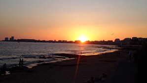 A beach at sunset with a city skyline in the background. - SEASIDE Maisonette - Residential area - 700m supervised beach PARKING (Château-D'olonne)