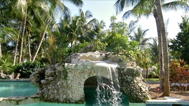 A pool with a natural rock formation and a waterfall feature. - Come Home to Sunrise Beach Villas, Paradise Island (Nassau)