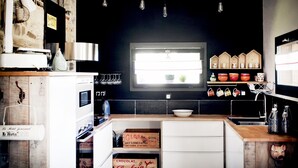Cocina con ventana, armarios de madera y varios electrodomésticos.