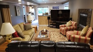 A living room with a sofa, armchairs, a coffee table, a TV, and a fireplace. - Elegant 2 King Bedroom Apt - 2 night minimum - 4 adults  (Traverse City)
