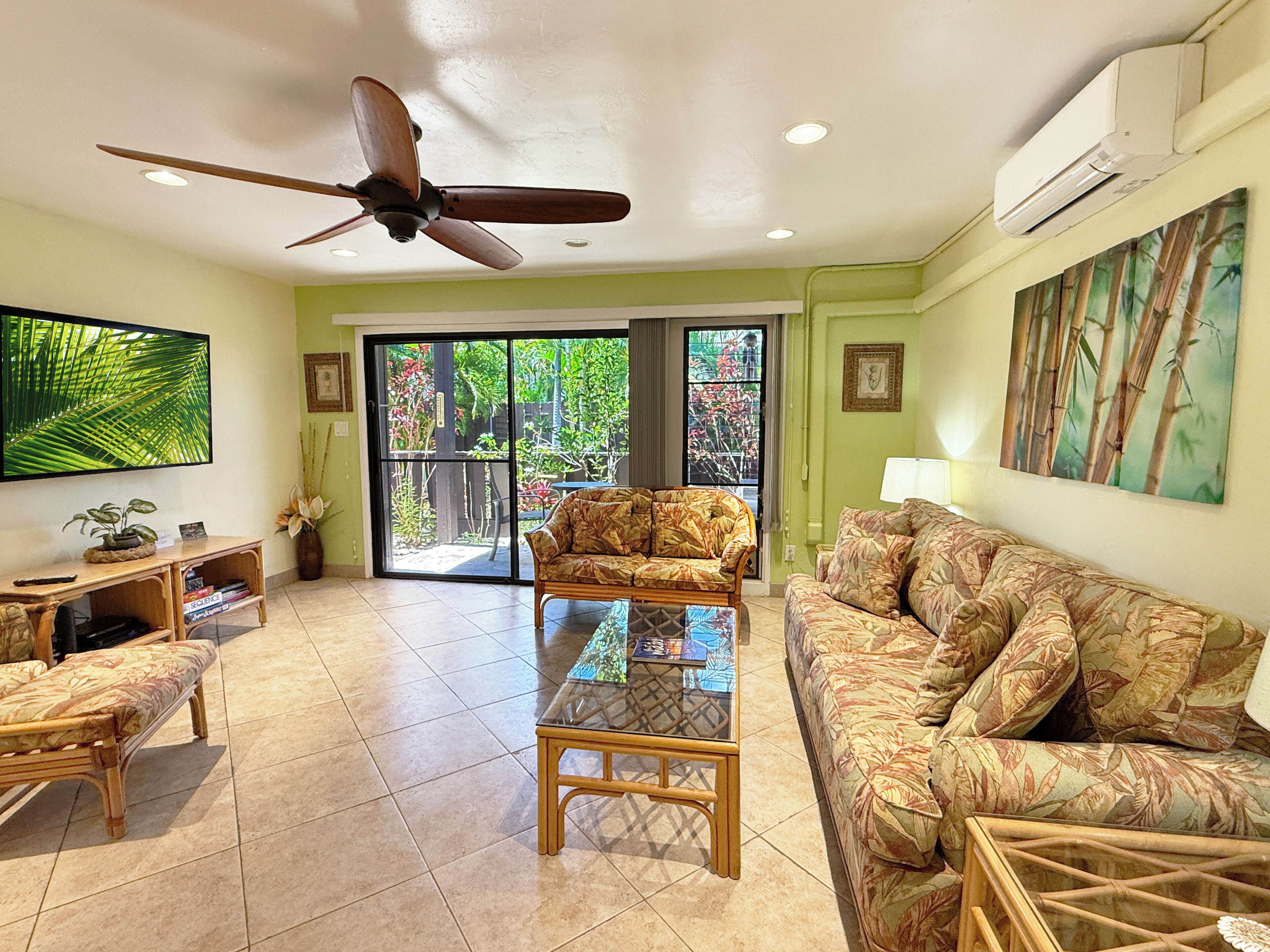 A living room with a ceiling fan, a sofa, a coffee table, and a TV.
