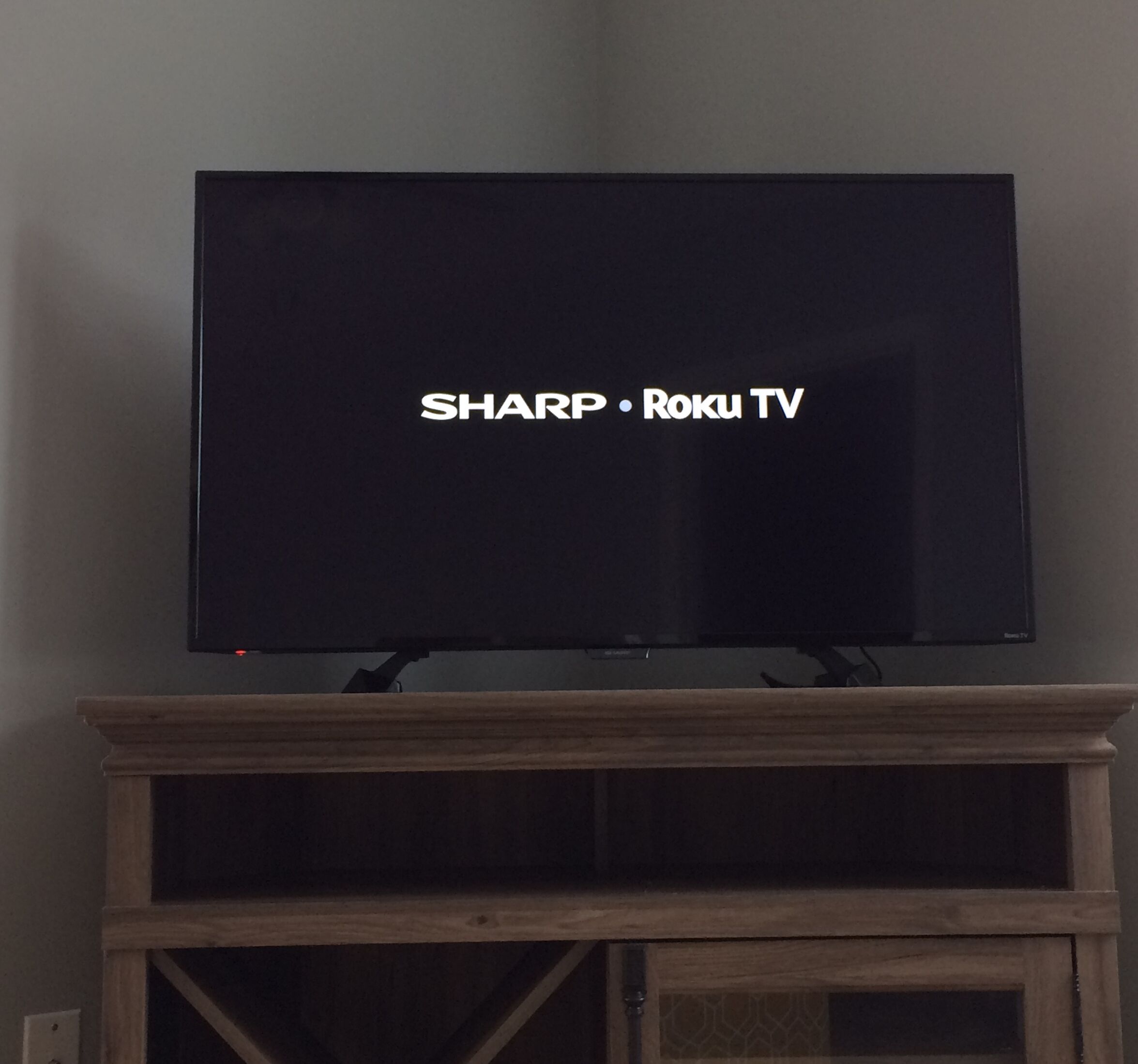 Un televisor de pantalla plana montado sobre un soporte de madera, con el texto 