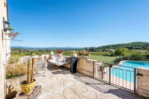 A patio with a pool, outdoor furniture, and a cactus plant.