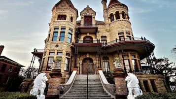 Un edificio grande y ornamentado con una entrada imponente, múltiples torres y estatuas en la base.