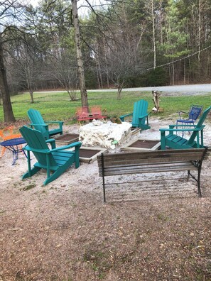 An outdoor seating area with several Adirondack chairs and a wooden bench. - 11 Acres | Fire Pit | Private Cabin| Pets Welcome (Gold Hill)