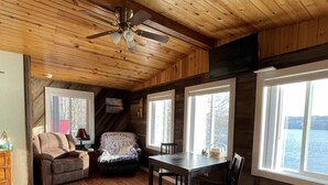 A cozy cabin interior with wooden floors, a dining table, a sofa, and a ceiling fan. - Unique Space-Great View, East side Sunsets a Plus -2 Nights or More :) (Niles)