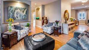 A modern living room with patterned sofas, a coffee table, and a large abstract painting. - Large Comfortable home with Flatiron views (Boulder)