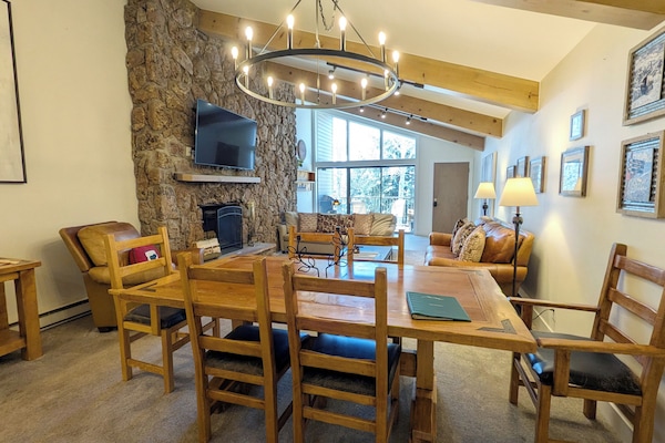 Living room with dining table, wood fireplace, and balcony with gas BBQ grill