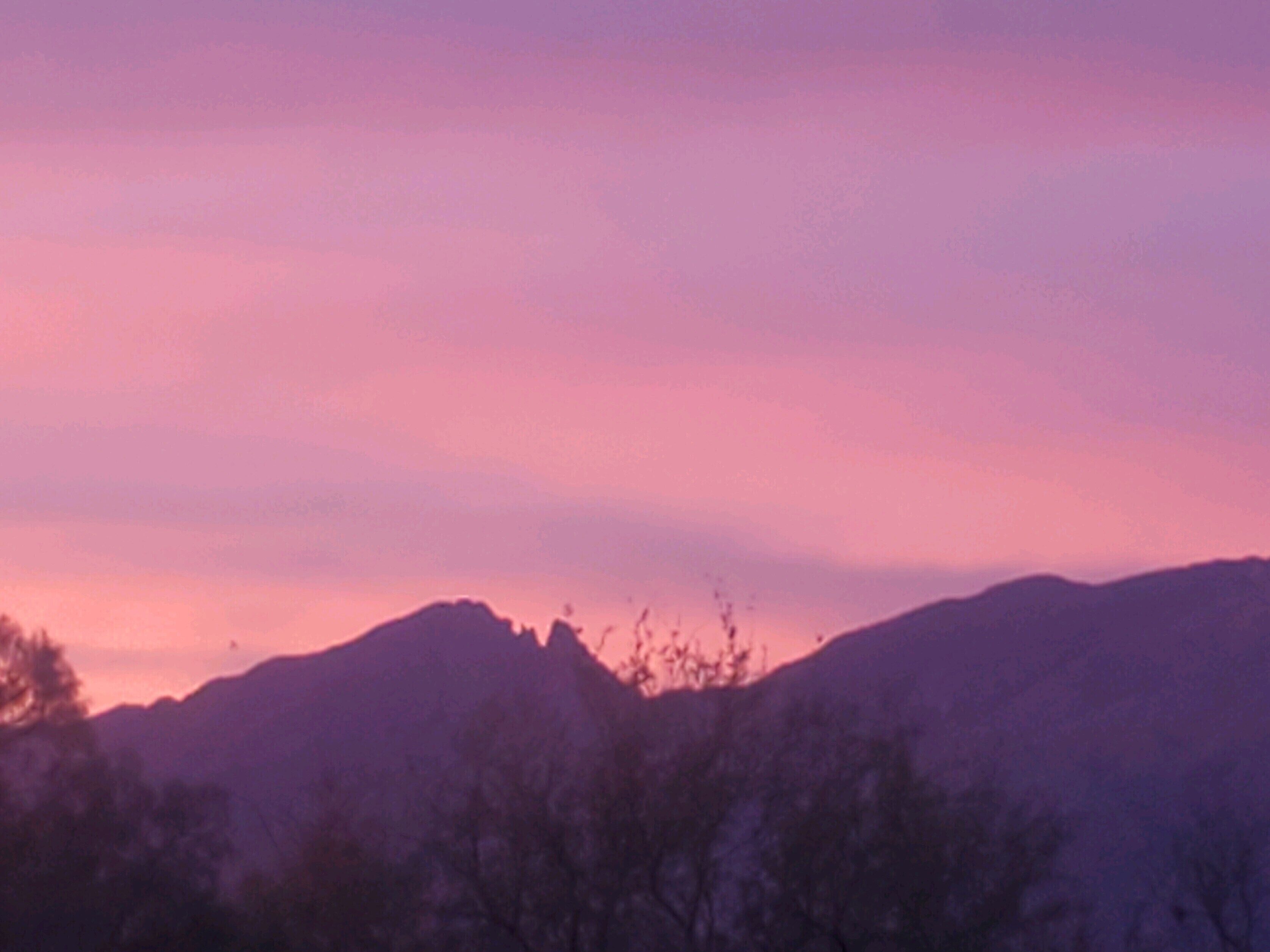 A mountain range with a pink sky.